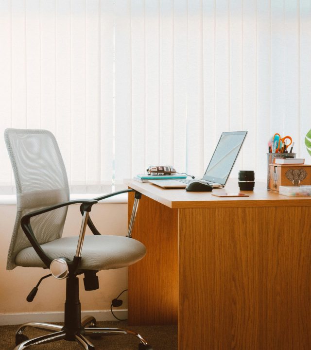 A tranquil modern home office featuring a wooden desk, ergonomic chair, and soft natural light.